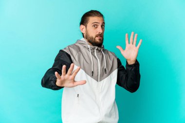 Uzun saçlı genç adam yakın bir tehlike yüzünden şoka girmiş gibi görünüyor.