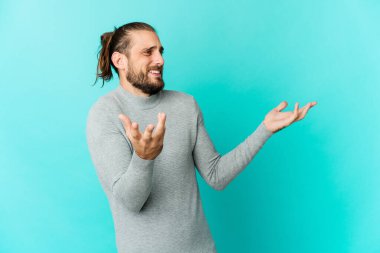 Uzun saçlı genç adam çok gülerken neşeli görünüyor. Mutluluk kavramı.