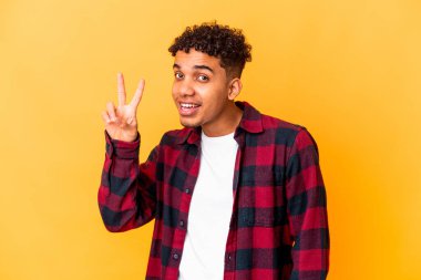 Genç Afro-Amerikalı kıvırcık adam iki numarayı parmaklarıyla gösteriyor..