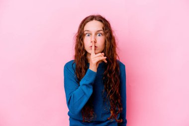 Pembe arka planda izole edilmiş küçük beyaz kız bir sır saklıyor ya da sessizlik istiyor..