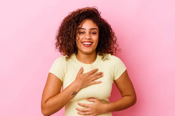 ピンクの背景に孤立した若いアフリカ系アメリカ人の女性が喜んで笑い 胃の上に手を保つ楽しみを持って — ストック写真