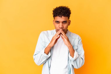 Genç Afro-Amerikan Kıvırcık Adam, mor bir plan üzerinde izole edilmiş, bir fikir kuruyor..