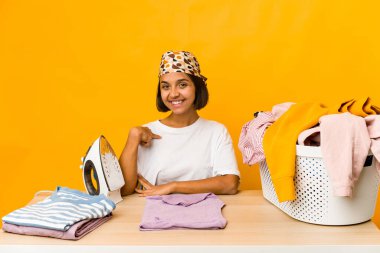 Giysileri ütüleyen genç İspanyol kadın gömlek fotokopisini elle gösteren, gururlu ve kendinden emin birini işaret ediyor.