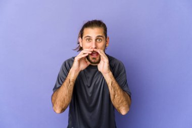 Uzun saçlı genç adam ellerini başının üstünde tutarak neşe içinde gülüyor. Mutluluk kavramı.