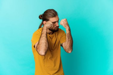 Uzun saçlı genç adam bir tartışma yüzünden yumruk atıyor, sinirleniyor, kavga ediyor, boks yapıyor..