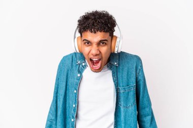 Genç Afro-Amerikalı kıvırcık adam kulaklıkla müzik dinleyip çok sinirli ve agresif bağırıyor..