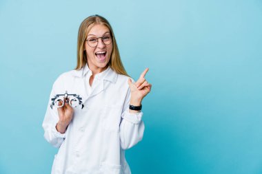 Mavi üzerindeki genç Rus optometrist kadın işaret parmağıyla fotokopi alanını işaret ederek heyecan ve arzusunu ifade ediyor..