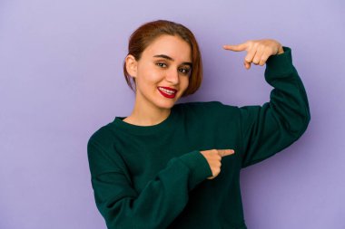 Genç Arap melez kadın işaret parmağıyla küçük bir şey tutuyor, gülümsüyor ve kendinden emin..