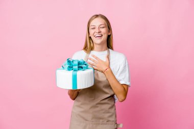 Genç Rus fırıncı kadın elinde lezzetli bir pasta tutarken kahkahalar atıyor..