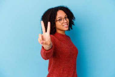 Genç Afro-Amerikan melez kadın izole edilmiş zafer işareti gösteriyor ve gülümsüyor..
