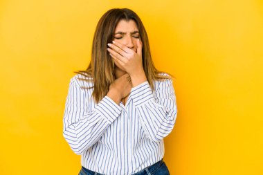 Sarı arka planda izole edilmiş genç Hintli kadın virüs ya da enfeksiyon yüzünden boğazında ağrı hissediyor..