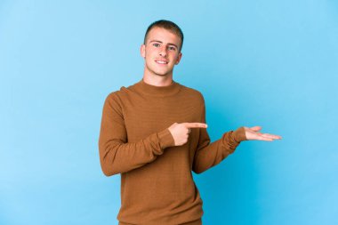 Beyaz tenli yakışıklı adam, elinde bir fotokopi odası tutarken heyecanlanıyor..