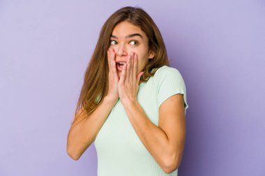 Mor arka planda genç, sıska, beyaz kız korkmuş ve korkmuş..