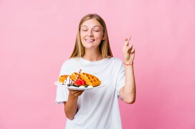 Waffle yiyen genç Rus kadın şans getirsin diye parmaklarını çaprazladı.