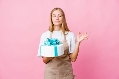 Genç Rus fırıncı kadın elinde lezzetli bir pasta tutarken sıkı çalışma gününden sonra rahatlıyor, yoga yapıyor..