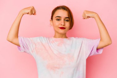 Genç Arap melez kadın güçlü hareketini kollarıyla gösteriyor, kadınsı gücün sembolü.