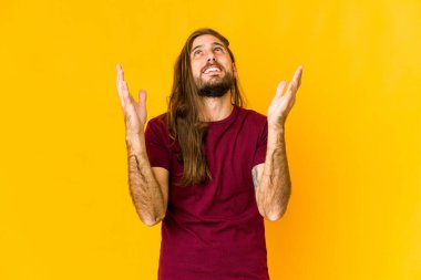 Uzun saçlı genç adam çok gülerken neşeli görünüyor. Mutluluk kavramı.