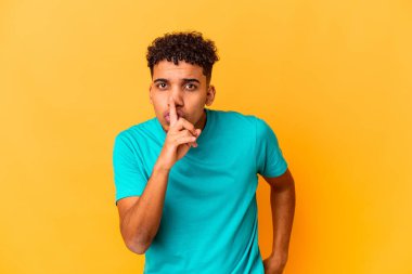 Genç Afro-Amerikalı kıvırcık adam, mor renkte izole edilmiş, sır saklıyor ya da sessizlik istiyor..