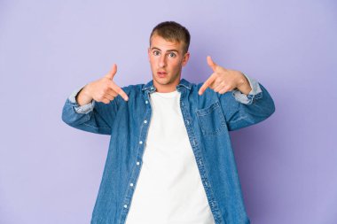 Beyaz tenli yakışıklı adam parmaklarıyla aşağı işaret ediyor, olumlu bir his..