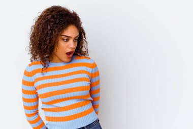 Beyaz arka planda izole edilmiş genç bir Afrikalı Amerikalı kadın gördüğü bir şey yüzünden şok oluyor..