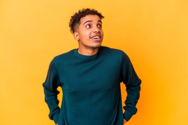 Genç Afro-Amerikan kıvırcık adamı mor, rahat ve mutlu bir şekilde izole edilmiş, boynunda dişleri olan..