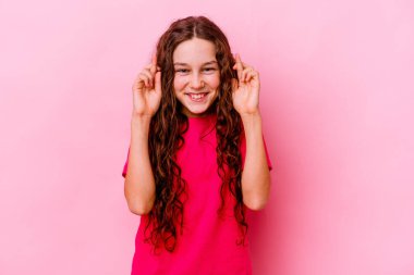 Pembe arka planda izole edilmiş küçük beyaz kız şans getirsin diye dua ediyor.