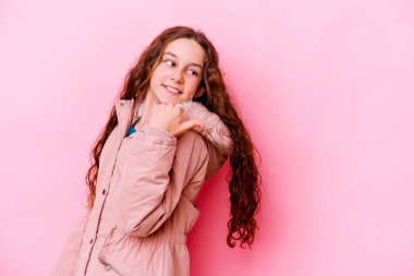 Küçük beyaz kız pembe arka plan noktalarında izole edilmiş, başparmak uzakta, gülüyor ve kaygısız..