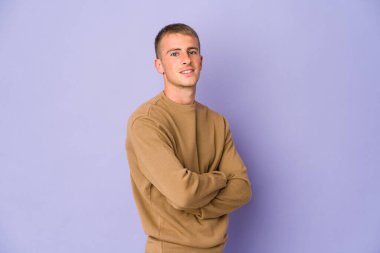 Kendine güveni tam, kararlılığıyla kollarını kavuşturan beyaz tenli yakışıklı bir adam..