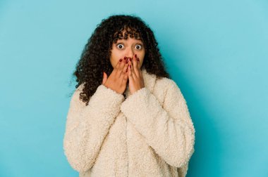 Genç Afrikalı Amerikalı afro kadın şok olmuş, ağzı ellerle kaplanmış, yeni bir şey keşfetmek için sabırsızlanıyor..