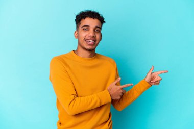 Genç Afro-Amerikalı kıvırcık adam mavi üzerine izole edilmiş..