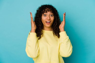 Genç Afrikalı Afro-Amerikan kadın bir zaferi ya da başarıyı kutluyor, şaşırıyor ve şok oluyor..