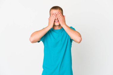 Beyaz tenli yakışıklı adam elleriyle gözlerini kapatıyor. Gülümsüyor ve bir sürpriz bekliyor..