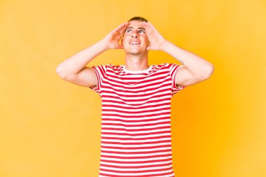 Kafkasyalı yakışıklı genç adam ellerini başının üstünde tutarak neşeyle gülüyor. Mutluluk kavramı.