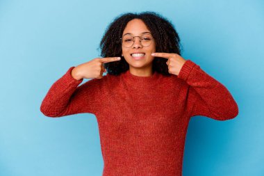 Genç Afro-Amerikan melez kadın tebessümlerini izole edip, parmaklarını ağıza doğrultuyor..
