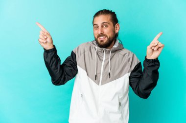 Uzun saçlı genç adam farklı fotokopi alanlarını işaret ediyor, birini seçiyor, parmaklarıyla gösteriyor..