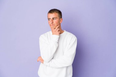 Kafkasyalı yakışıklı bir genç şüpheli ve şüpheci bir ifadeyle yana bakıyor..