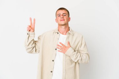 Beyaz tenli yakışıklı bir adam yemin ediyor, elini göğsüne koyuyor..