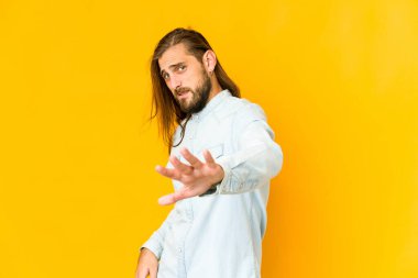 Uzun saçlı genç adam iğrenme hareketi yapan birini reddediyor..