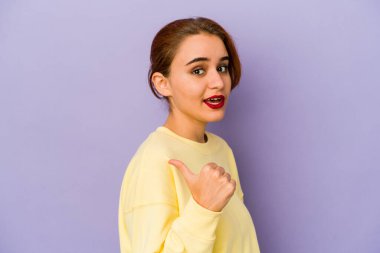 Genç Arap melez kadın başparmağıyla işaret ediyor, gülüyor ve kaygısız..