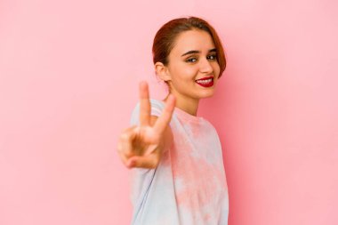 Genç Arap melez kadın neşeli ve kaygısız parmaklarıyla barış sembolü gösteriyor..