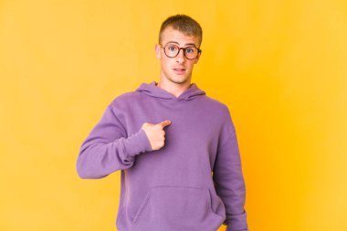 Genç, beyaz, yakışıklı bir adam parmağını gösterip, gülümseyerek şaşırdı..