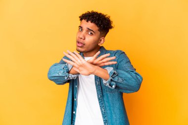 Genç Afro-Amerikan kıvırcık adamı, mor renkte izole edilmiş, inkar hareketi yapıyor.