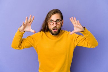 Uzun saçlı genç adam zaferi ya da başarıyı kutluyor gibi görünüyor. Şaşırdı ve şok oldu..