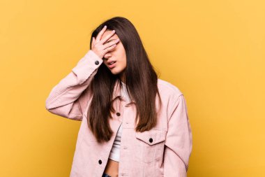 Sarı arka planda izole edilmiş genç Hintli kadın tapınaklara dokunuyor ve baş ağrısı çekiyor..