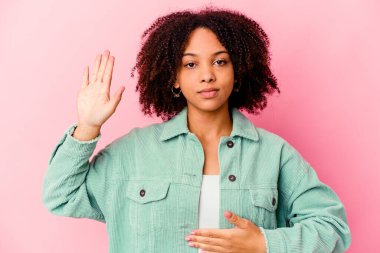 Genç Afro-Amerikan melez kadın tek başına yemin ediyor, elini göğsüne koyuyor..