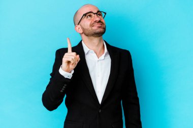 Mavi arka planda izole genç beyaz adam iki ön parmakları boş bir boşluk gösteren gösterir.