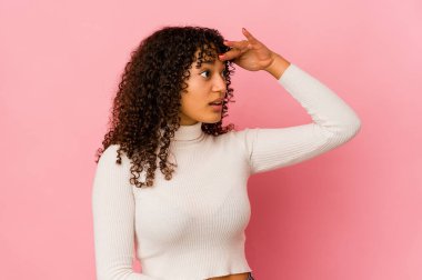 Genç Afro-Amerikan Afro kadın uzaklardan izole edilmiş, elini alnına koyuyor..