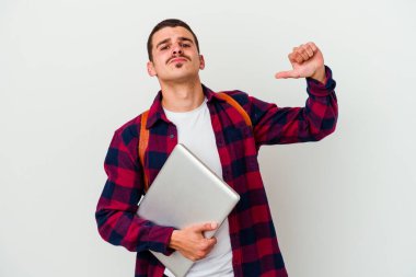 Beyaz arka planda izole edilmiş dizüstü bilgisayar tutan genç beyaz bir öğrenci gururlu ve kendinden emin hissediyor, örnek olarak.