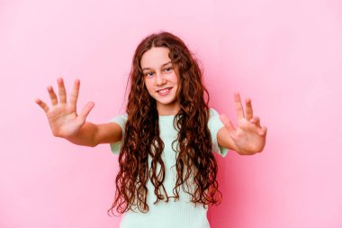 Pembe arka planda izole edilmiş küçük beyaz kız zaferi ya da başarıyı kutluyor, şaşırıyor ve şok oluyor..