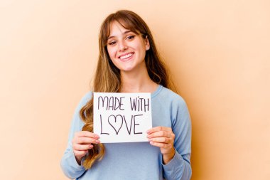Genç, beyaz bir kadın elinde aşk levhasıyla izole edilmiş mutlu, güler yüzlü ve neşeli bir kadın..